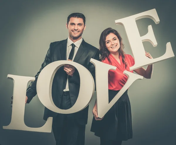 Couple holding word LOVE — Stock Photo, Image