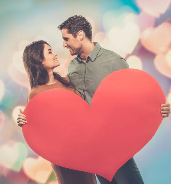 Casal feliz segurando coração de papel artesanal — Fotografia de Stock