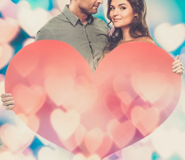 Happy couple holding handmade paper heart — Stock Photo, Image