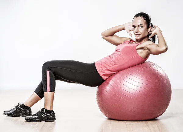 Atletische vrouw doen oefening op een fitness bal — Stockfoto