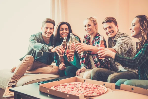 Amigos multiétnicos con pizza y botellas de bebida —  Fotos de Stock