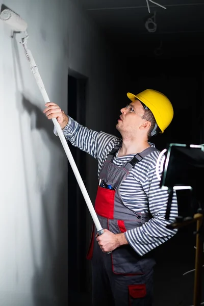 Builder tillämpa färgen på en vägg med rulle — Stockfoto