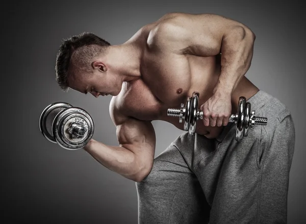 Homem muscular exercitando com halteres — Fotografia de Stock