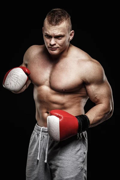 Muscular young man wearing boxing gloves — Stock Photo, Image