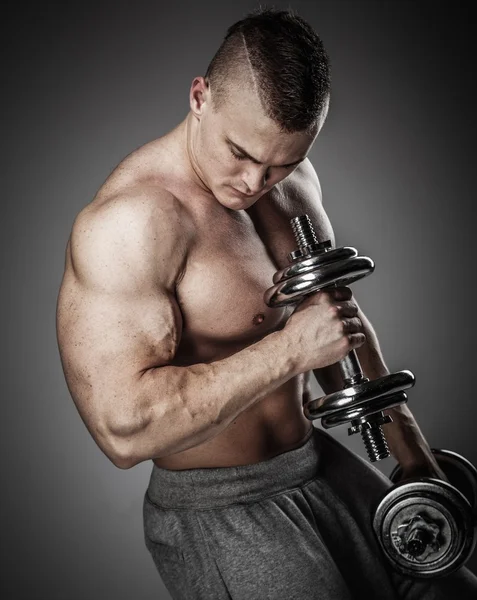 Hombre musculoso haciendo ejercicio con pesas — Foto de Stock