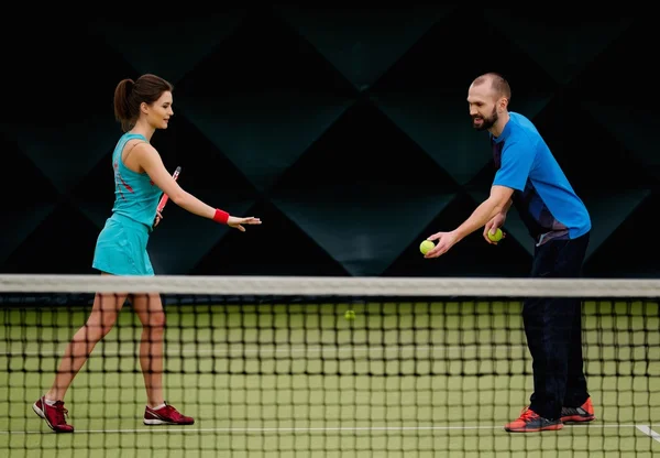 Kvinnan och hennes tränare som tränar på en tennisbana — Stockfoto