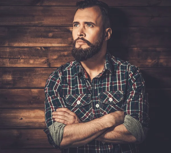 Man in checkered shirt, wooden house interior — Stock Photo, Image