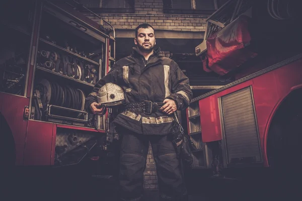 Bombeiro perto de caminhão com equipamento — Fotografia de Stock