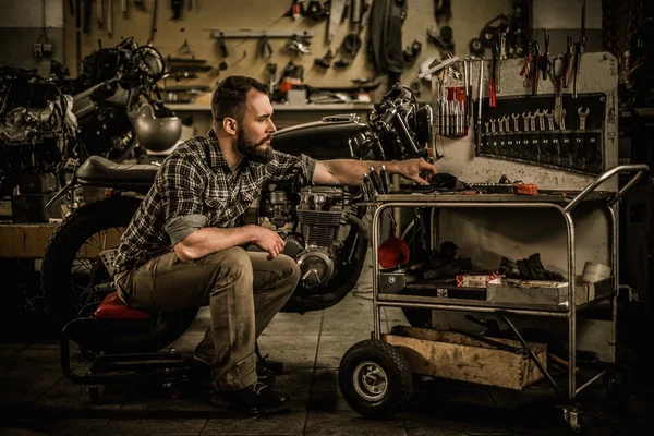 Mechanic gebouw vintage stijl café-racer motorfiets in aangepaste garage — Stockfoto