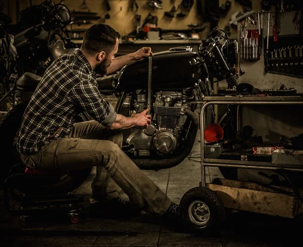 Mechanic gebouw vintage stijl café-racer motorfiets in aangepaste garage — Stockfoto