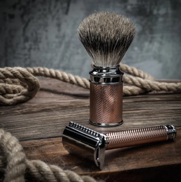 Запобіжна бритва та щітка для гоління на дерев'яному фоні — стокове фото