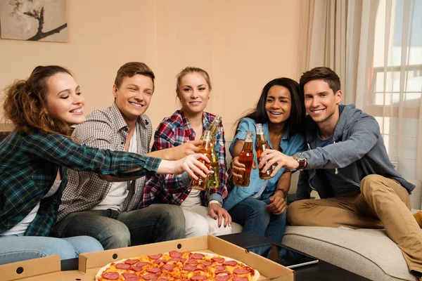 Groupe d'amis multiethniques avec pizza et bouteilles de boissons faisant la fête — Photo