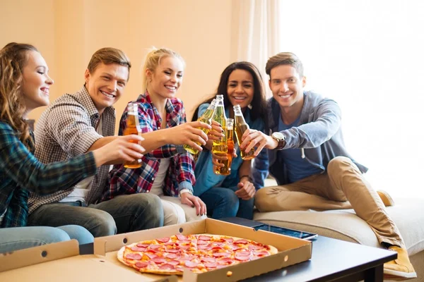 Мультиэтнические друзья с пиццей и бутылками напитков, устраивающие вечеринку — стоковое фото