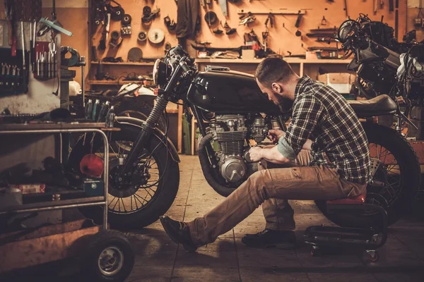 Mechanik budowy stylu vintage Cafe racer motocykl w garażu niestandardowe — Zdjęcie stockowe