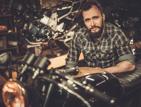 Mechanik budování vintage stylu café-racer motocykl ve vlastní garáži — Stock fotografie
