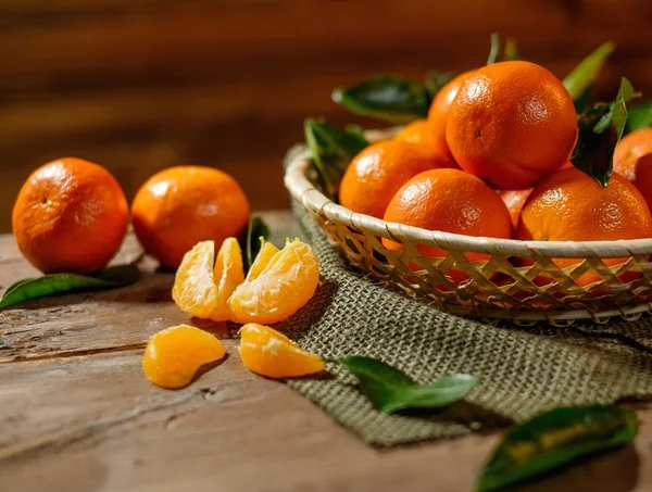 Cesta con sabrosas mandarinas sobre una mesa de madera —  Fotos de Stock