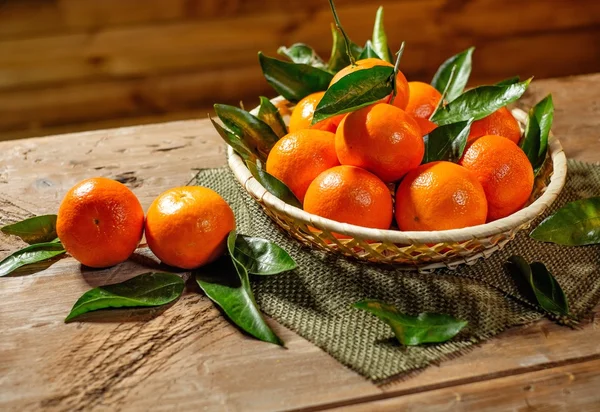 Basket with tasty tangerines on a wooden table — Stok fotoğraf
