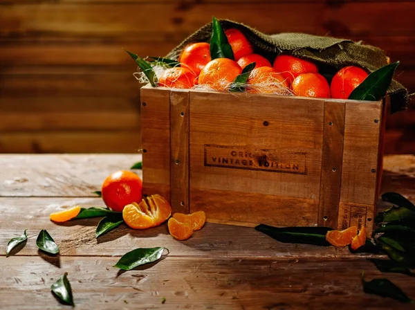 Holzkiste mit leckeren Mandarinen auf einem Tisch — Stockfoto