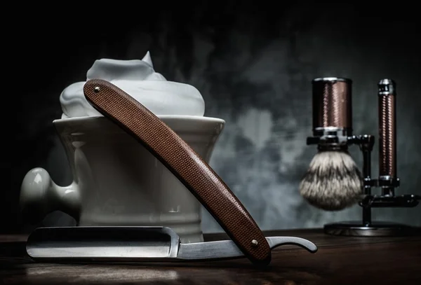 Shaving razors and bowl with foam on wooden background — Stockfoto