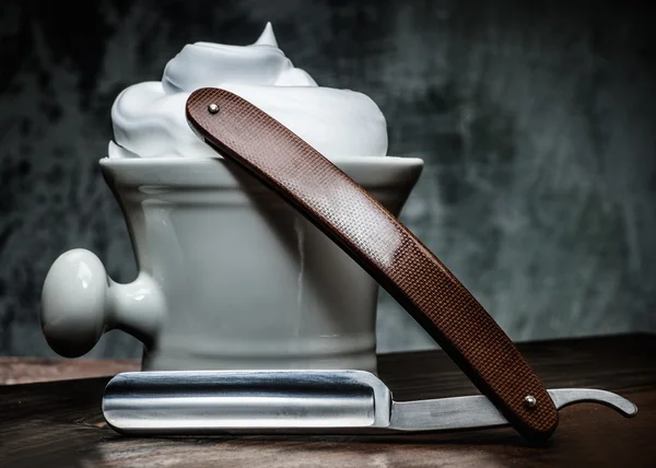 Shaving bowl and straight razor on wooden background — Stock Photo, Image