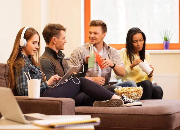 Glada studenter med drinkar och popcorn — Stockfoto