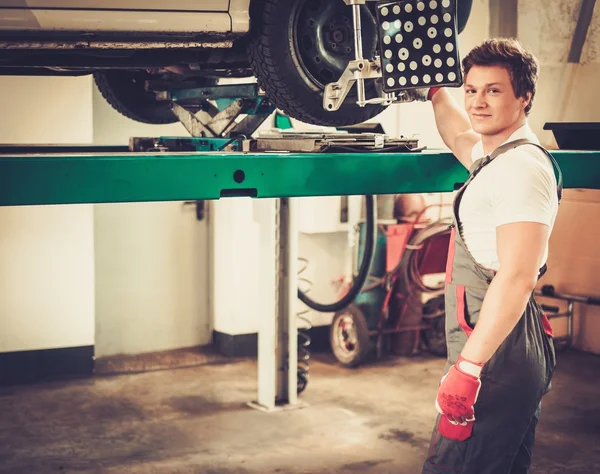 Servicekraft überprüft Fahrwerkvermessung in einer Kfz-Werkstatt — Stockfoto