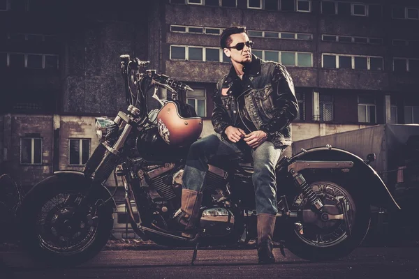 Biker and his bobber style motorcycle on a city streets — Stock Photo, Image