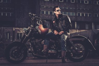 Biker and his bobber style motorcycle on a city streets  clipart