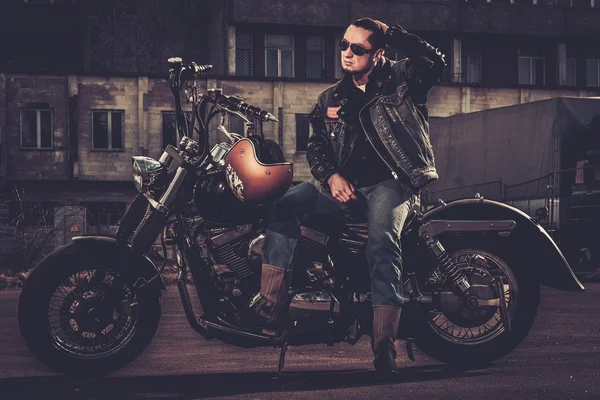 Biker and his bobber style motorcycle on a city streets — Stock Photo, Image