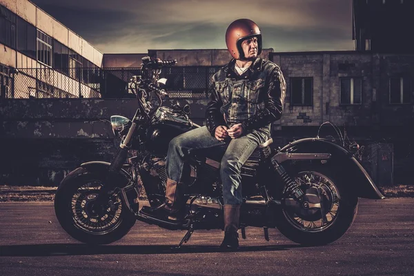 Biker and his bobber style motorcycle on a city streets — Stock Photo, Image