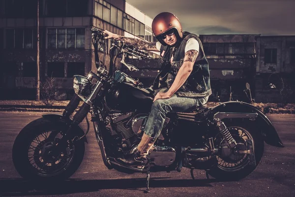 Biker and his bobber style motorcycle on a city streets — Stock Photo, Image