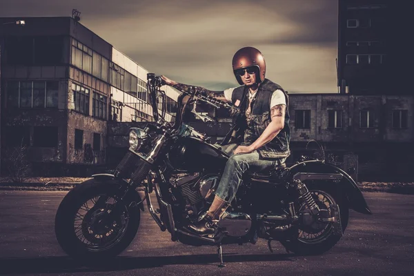 Biker and his bobber style motorcycle on a city streets — Stock Photo, Image