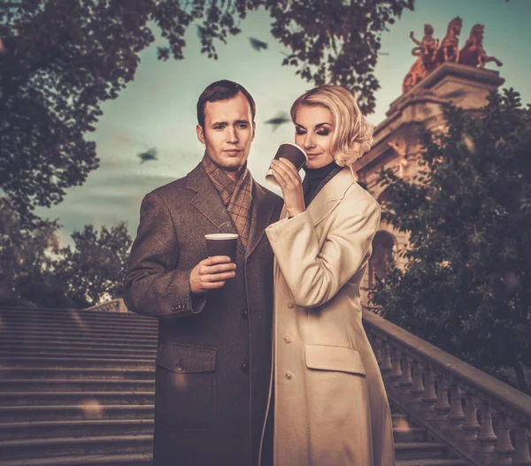 Élégant couple à l'extérieur avec des tasses de boisson chaude — Photo