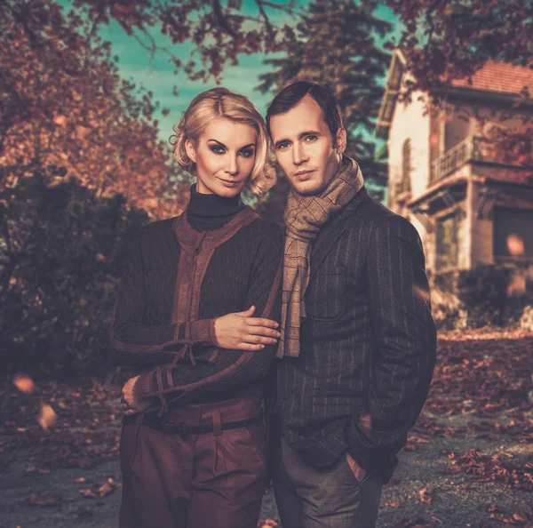 Elegant couple against country house on autumn day — Stock Photo, Image