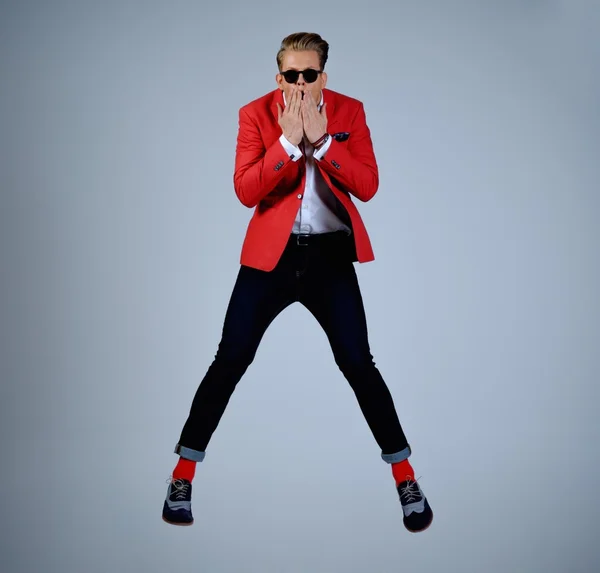 Homem elegante em casaco vermelho se divertindo pulando — Fotografia de Stock