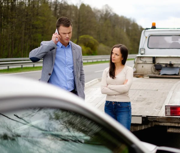 Pareja cerca de coche roto en una carretera — Foto de Stock