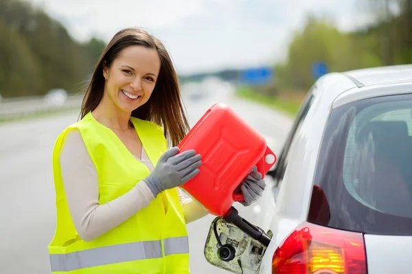 Vrouw bijtanken van haar auto op een snelweg langs de weg — Stockfoto