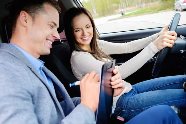 Instrutor de condução e estudante mulher em carro exame — Fotografia de Stock