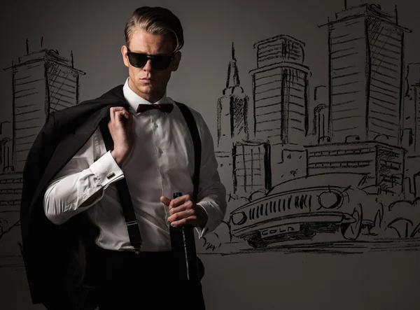 Sharp vestido con botella de vino contra el dibujo de la ciudad — Foto de Stock