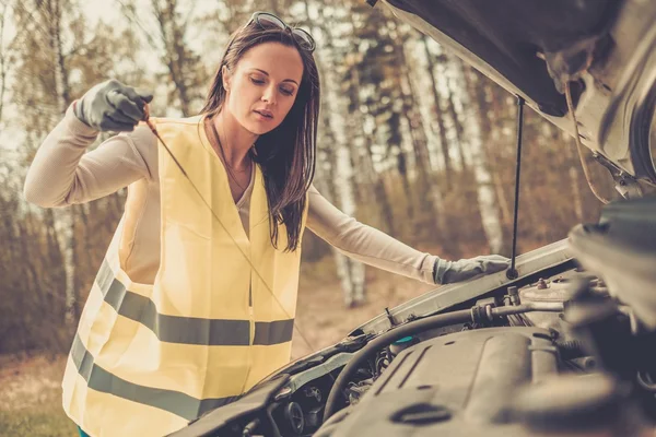 Woman checking oil level on  a roadside — Stock Photo, Image