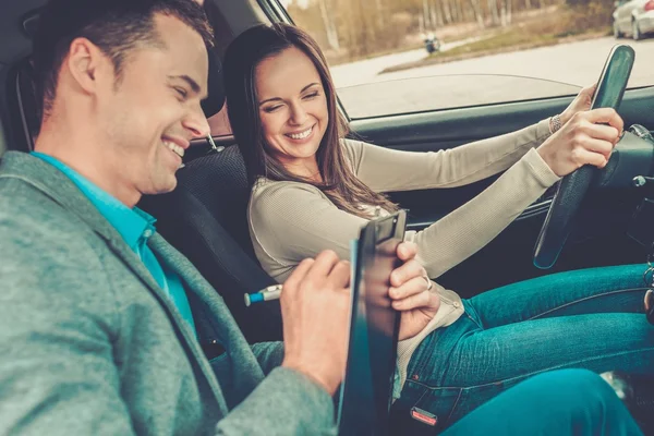 Instrutor de condução e estudante mulher em carro exame — Fotografia de Stock