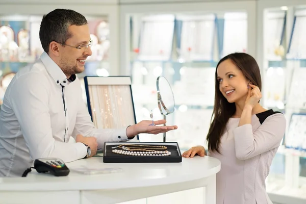 Vrouw met assistent hulp bij het kiezen van juwelen — Stockfoto