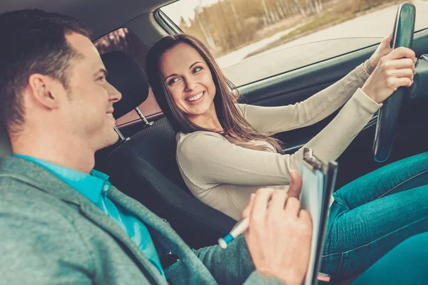 Instrutor de condução e estudante mulher em carro exame — Fotografia de Stock