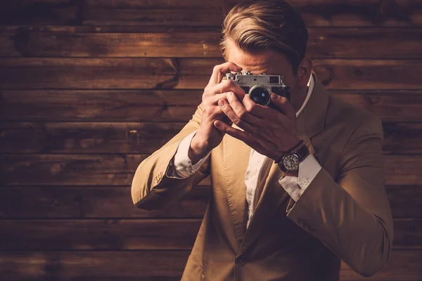 Stijlvolle man met retro camera in landelijk gelegen vakantiehuis interieur — Stockfoto