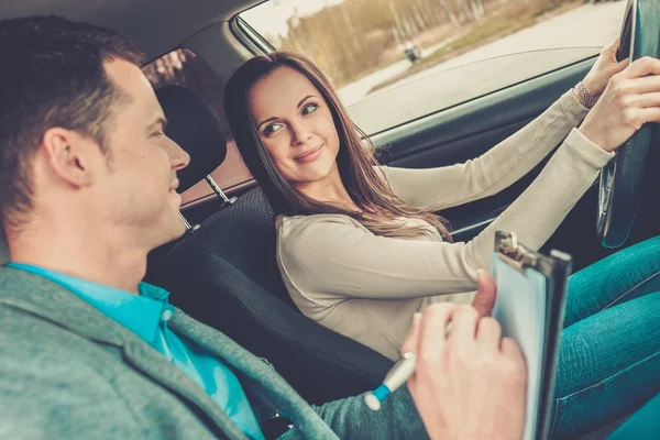 Instrutor de condução e estudante mulher em carro exame — Fotografia de Stock