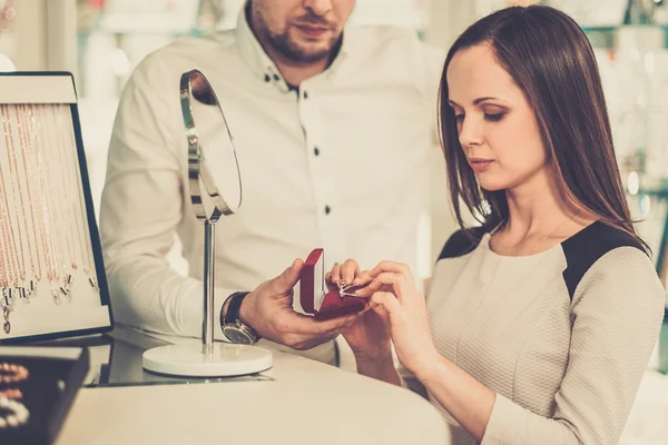 Vrouw met assistent hulp bij het kiezen van juwelen — Stockfoto