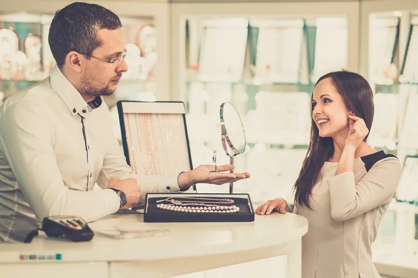 Vrouw met assistent hulp bij het kiezen van juwelen — Stockfoto