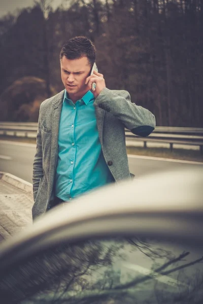 Un uomo che chiama mentre il carro attrezzi prende la sua auto — Foto Stock