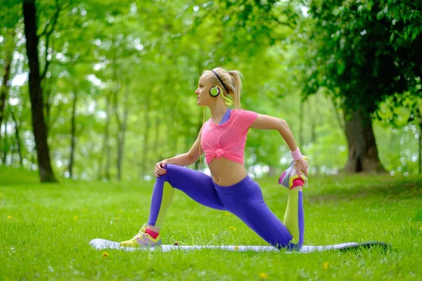 Sportiga kvinnan gör fitnessövningar utomhus — Stockfoto