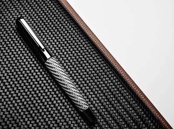 Rollerball pen on a carbon surface — Stock Photo, Image